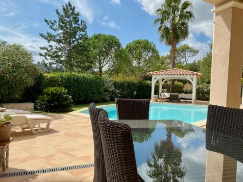 um pátio com uma piscina e cadeiras e um gazebo em Magnifique villa avec piscine en Provence Verte em La Roquebrussanne