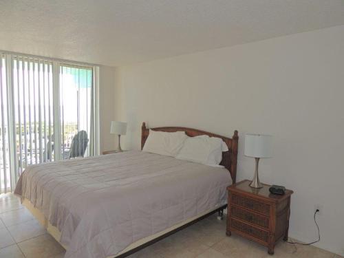1 dormitorio con 1 cama grande y balcón en Renovated, Ocean Beach Villas Unit 201- Direct Oceanfront Condo! en Cocoa Beach