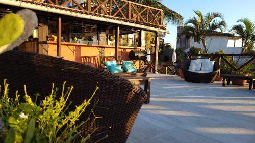 a patio with chairs and a building with a bar at Pousada Vila do Sol in Búzios