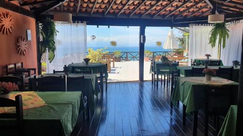 a restaurant with tables and chairs with a view of the ocean at Pousada Vila do Sol in Búzios