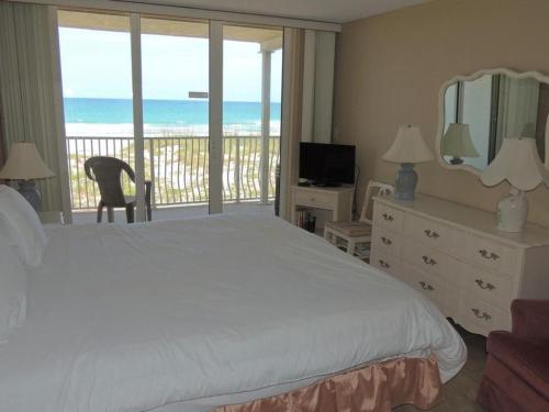 um quarto com uma cama e uma varanda com o oceano em Ocean Beach Villas Unit 302- Direct Oceanfront Condo! em Cocoa Beach