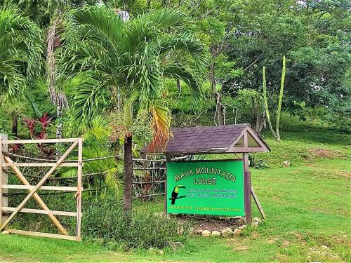 a sign for a monkey mountain lodge in a park at Maya Mountain Lodge in San Ignacio