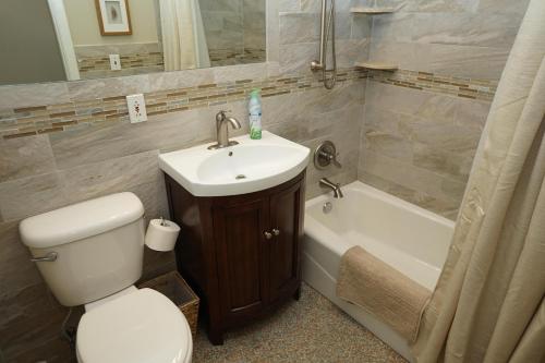 a bathroom with a sink and a toilet and a bath tub at NEW! 219 Garfield Ave in Cocoa Beach