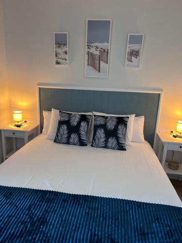 una camera da letto con un grande letto bianco con due lampade di Apartamento Las vistas a Morro del Jable