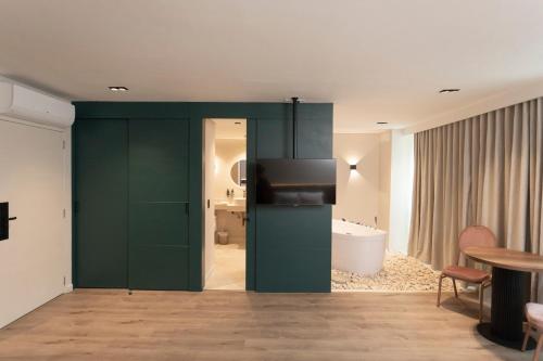 a bathroom with a green door and a bathroom with a tub at 1616 Hotel in Medellín