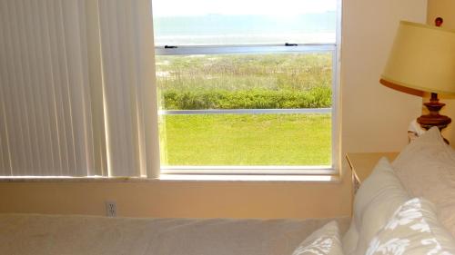 une chambre avec un lit et une fenêtre avec vue dans l'établissement Spanish Main 63- Rare Direct Oceanfront 3 BR Condo!, à Cocoa Beach