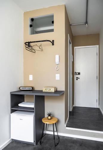 a room with a desk and a door and a stool at ZEST Teodoro in Sao Paulo