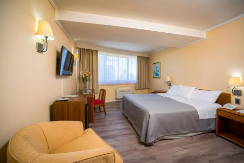 a hotel room with a bed and a chair at Hotel Diego de Almagro Concepción in Concepción