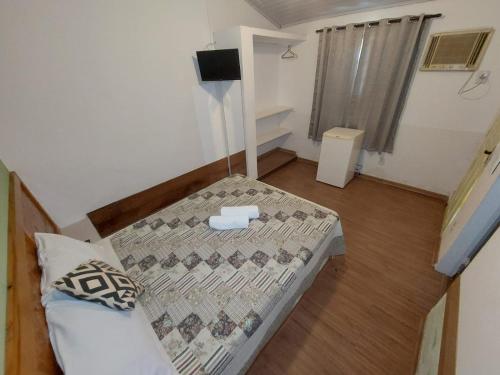 Cette petite chambre comprend un lit. dans l'établissement Suites por do Sol, à Búzios