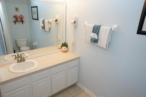une salle de bain avec un lavabo et un miroir dans l'établissement Windsor Hills Resort- 7665 Sir Kaufmann, à Kissimmee
