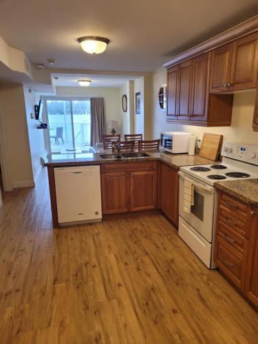 a kitchen with wooden cabinets and white appliances at Muskoka Lakes Hotel and Resorts in Port Carling