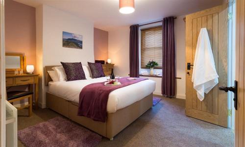 a bedroom with a large bed and a window at The Cats Bield in Keswick