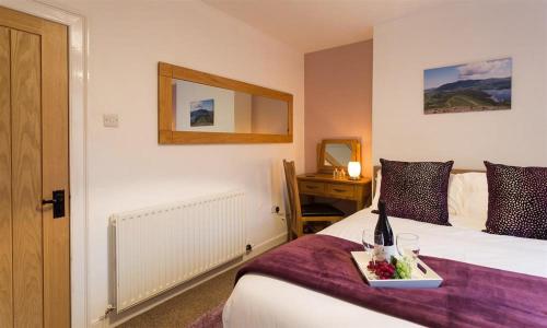 a hotel room with a bed with a tray of food on it at The Cats Bield in Keswick