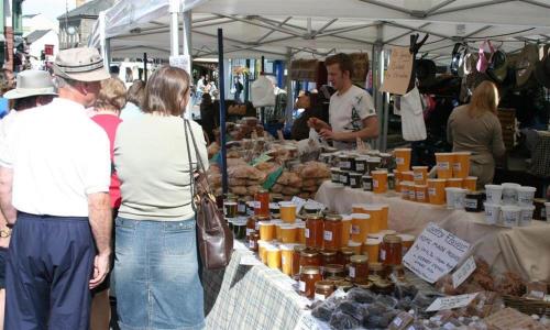 a group of people standing at a farmers market at The Cats Bield in Keswick