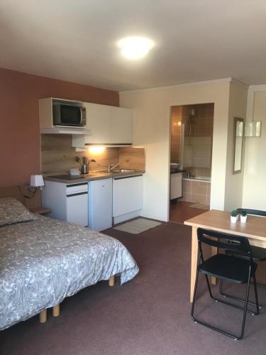 une chambre d'hôtel avec un lit, un bureau et une cuisine dans l'établissement La Féclaz Ski aux pieds Grand Studio Tout confort, à Les Déserts