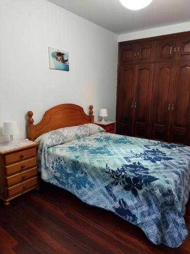 ビラガルシーア・デ・アロウサにあるPiso en Villagarcia de Arosaのベッドルーム1室(ベッド1台、ドレッサー、キャビネット付)