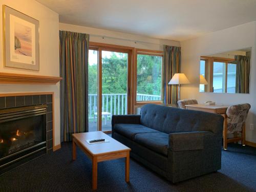 a living room with a couch and a fireplace at AppleCreek Resort-Hotel & Suites in Fish Creek