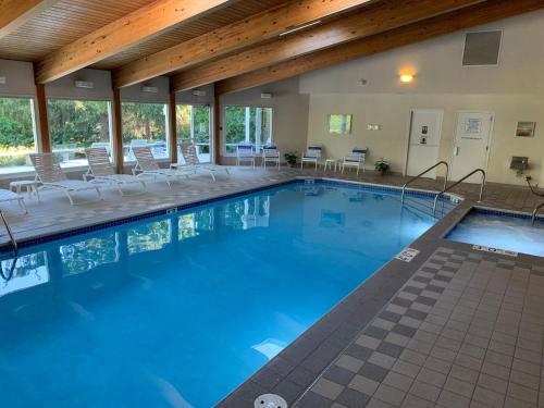 魚溪的住宿－AppleCreek Resort-Hotel & Suites，大楼内带桌椅的大型游泳池