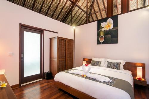 a bedroom with a large bed and a large window at Villa Keluarga in Nusa Lembongan