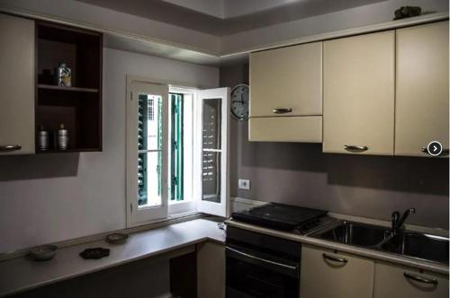 a kitchen with a stove and a sink and a window at Parva Domus in Modica