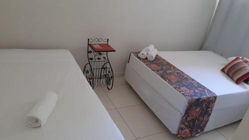 a bedroom with two beds and a night stand at Hotel Pousada Riacho da Areia in Águas de Lindóia
