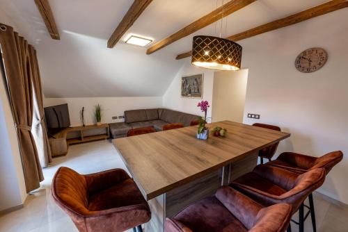 a dining room with a wooden table and leather chairs at Apartments Galunder in Veržej