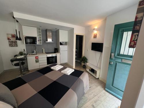 a bedroom with a black and white bed and a kitchen at Studio in Center of Lisbon in Lisbon