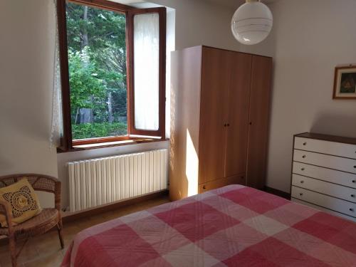 1 dormitorio con cama, ventana y vestidor en La Casa di Anna nel Parco della Majella Abruzzo Rapino CH, en Rapino