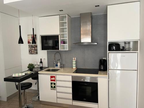 a kitchen with a white refrigerator and a sink at Studio in Center of Lisbon in Lisbon