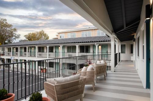 an outdoor patio with chairs and a railing at Kasa Palo Alto in Palo Alto