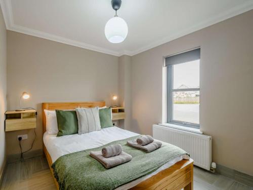 1 dormitorio con 1 cama con toallas en Westertonhill Lodge 5 Newbuild with Hot Tub Option, en Balloch