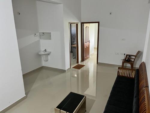 a white room with a sink and a mirror at Wayanad Biriyomz Residency, Kalpatta, Low Cost Rooms and Deluxe Apartment in Kalpetta