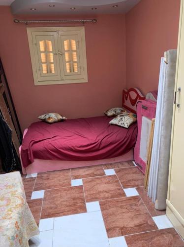 a small bedroom with a pink bed in a room at شقة مفروشة باامبابة in Cairo