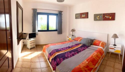 a bedroom with a bed and a television in it at Strandapartment Costa Luz-Ozean View in Tías