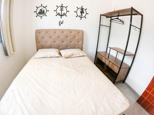 a bedroom with a bed with a white bedspread at APARTAMENTO COM PISCINA E CHURRASQUEIRA in Ubatuba