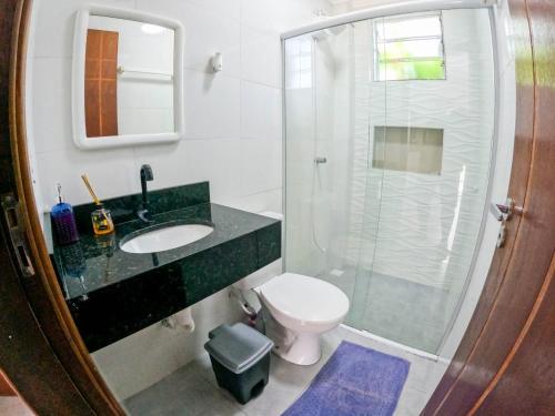 a bathroom with a toilet and a sink and a shower at APARTAMENTO COM PISCINA E CHURRASQUEIRA in Ubatuba