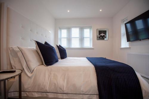 a bedroom with a large white bed with blue pillows at Luxury House in Clitheroe in Clitheroe