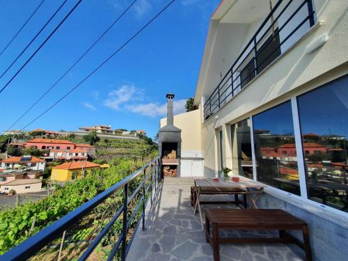 a balcony with benches and a view of a city at Casa das Feiteiras by AnaLodges in Ponta Delgada