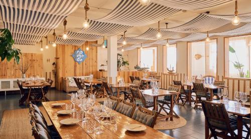 a dining room with wooden tables and chairs at Costa do Vizir Beach Village in Porto Covo