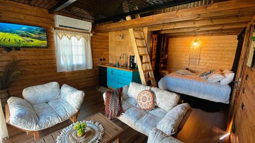 a living room with a bed and a bedroom in a log cabin at בקתת החרמון in Mas'ada