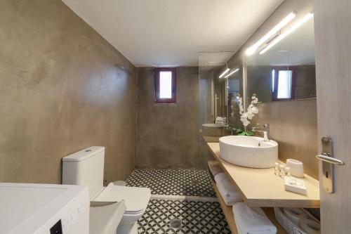 a bathroom with a sink and a toilet and a mirror at Villa Vigles in Maroulás