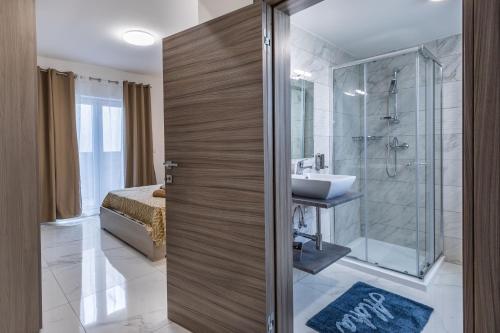 a bathroom with a shower and a sink and a toilet at Terrace View - Stylish Two Bedroom Penthouse in Msida