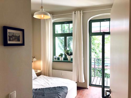a bedroom with a bed and two windows at Hip & Minimalist - Stadt Apartments am Malerweg in Pirna