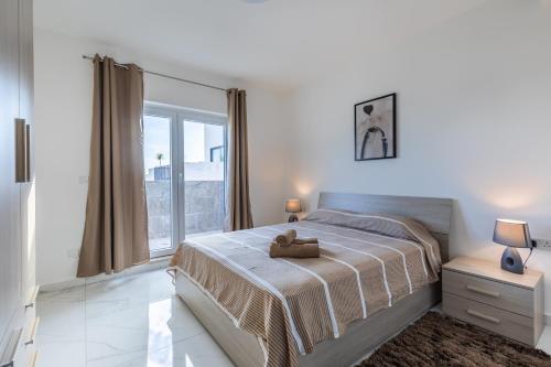 a bedroom with a bed with a teddy bear on it at Terrace View - Stylish Two Bedroom Penthouse in Msida