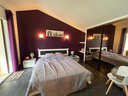 ein Schlafzimmer mit einem weißen Bett und einer lila Wand in der Unterkunft villa l'indoun in Seignosse