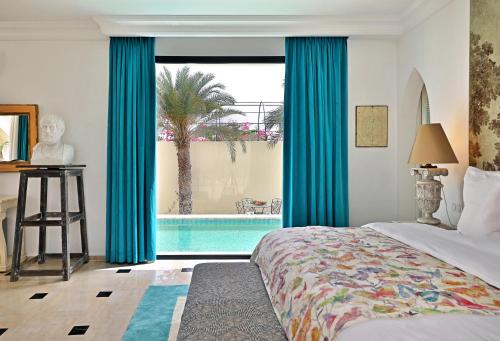 a bedroom with a bed and a view of a swimming pool at DAR OOMI in Zarzis