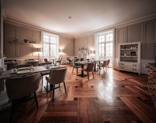 Hotel Ô Château في Hayange: غرفة طعام كبيرة مع طاولات وكراسي