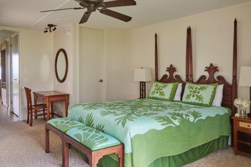 a bedroom with a large green bed with a fan at The Cliffs at Princeville in Princeville
