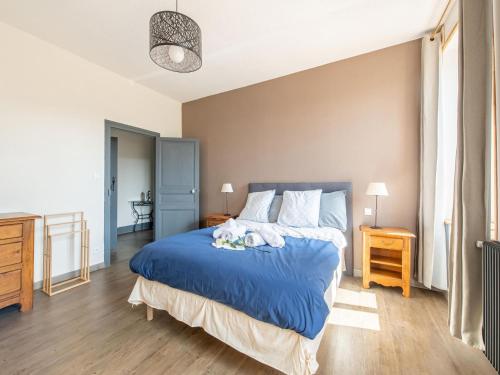 1 dormitorio con 1 cama grande con sábanas azules en Gite de l'Arboretum, en Dompierre-les-Ormes