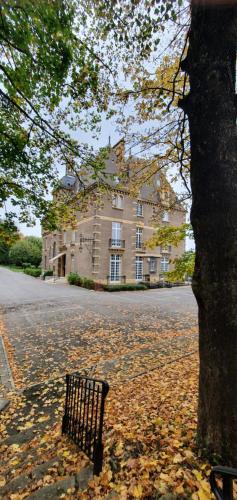 a park bench in front of a large building at Hotel Ô Château in Hayange